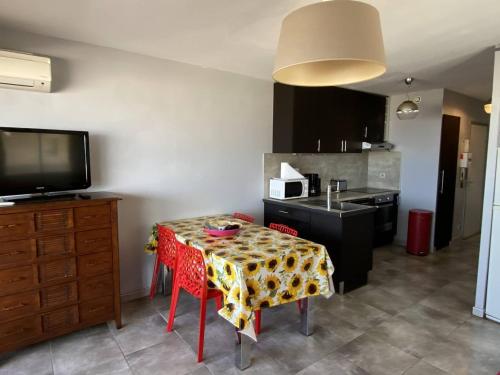 une cuisine avec une table recouverte d'une nappe dans l'établissement Deux-pièces climatisé, 4 pers, vue mer - FR-1-750-116, à Canet