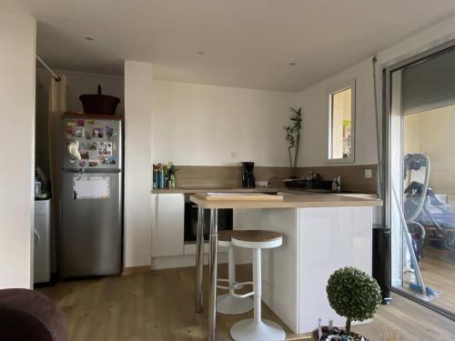 Il comprend une cuisine équipée d'un comptoir et d'un réfrigérateur. dans l'établissement Appartement rénové au calme près de la plage avec WiFi et parking privé - FR-1-750-115, à Canet