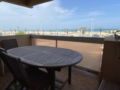 une table et des chaises sur un balcon avec vue sur la plage dans l'établissement Deux-pièces climatisé, 4 pers, vue mer - FR-1-750-116, à Canet