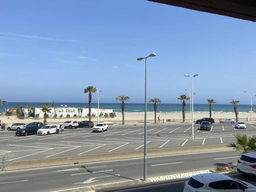 - un parking à côté de la plage avec des voitures dans l'établissement Deux-pièces climatisé, 4 pers, vue mer - FR-1-750-116, à Canet