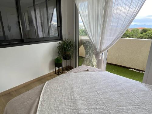 une chambre avec un lit et une fenêtre dans l'établissement Appartement rénové au calme près de la plage avec WiFi et parking privé - FR-1-750-115, à Canet
