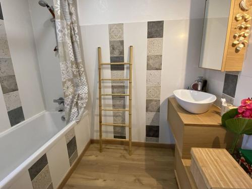 une salle de bain avec une baignoire blanche et un lavabo dans l'établissement Appartement rénové au calme près de la plage avec WiFi et parking privé - FR-1-750-115, à Canet