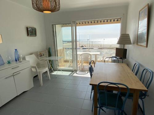 une cuisine et une salle à manger avec une table et des chaises dans l'établissement Trois-pièces 3* face mer, centre Canet-Plage - FR-1-750-117, à Canet