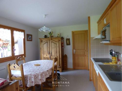 une cuisine avec une table et une salle à manger dans l'établissement Appartement lumineux près des pistes, 3 chambres, 7 personnes - FR-1-458-216, au Grand-Bornand