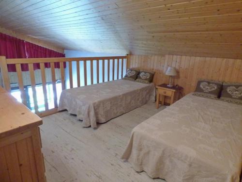 - une chambre avec 2 lits dans une cabane en bois dans l'établissement Charmant appartement 6 pers avec balcon sud au Grand-Bornand - FR-1-458-222, au Grand-Bornand