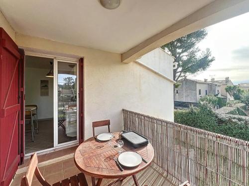 une table en bois assise sur un balcon avec une table dans l'établissement Appartement lumineux près de la plage avec parking sécurisé à Saint-Cyr-sur-Mer - FR-1-770-49, à Saint-Cyr-sur-Mer