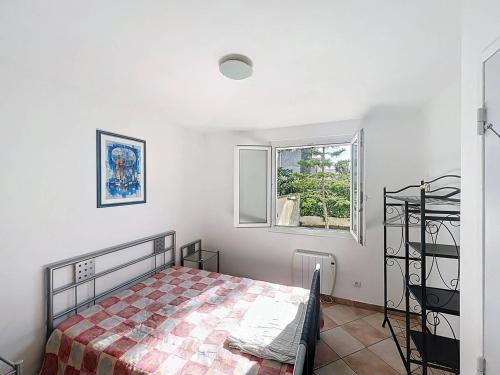 une chambre avec un lit et une fenêtre dans l'établissement Appartement paisible à 100m de la plage, avec jardin - FR-1-770-50, à Saint-Cyr-sur-Mer