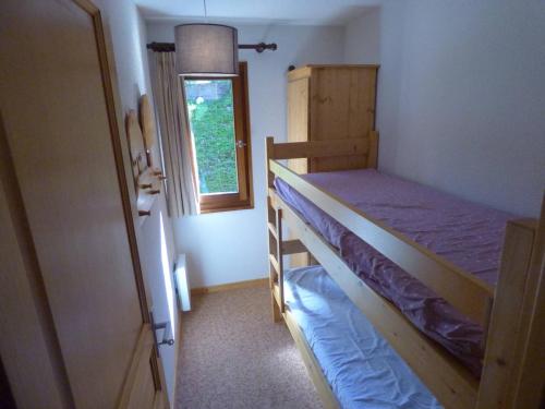 une chambre avec deux lits superposés et une fenêtre dans l'établissement Charmant T3 ski aux pieds, 6 pers, balcon, garage - FR-1-458-217, au Grand-Bornand