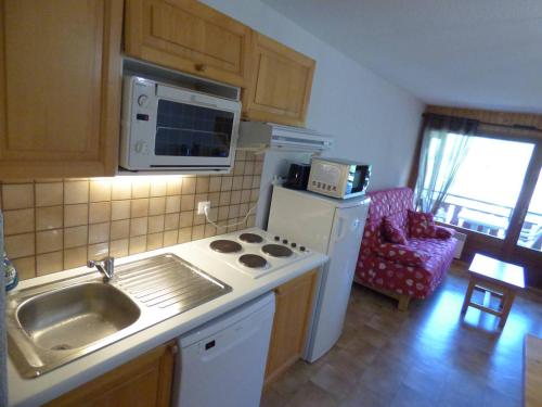 une cuisine avec un évier et une cuisinière four supérieur dans l'établissement Charmant T3 ski aux pieds, 6 pers, balcon, garage - FR-1-458-217, au Grand-Bornand