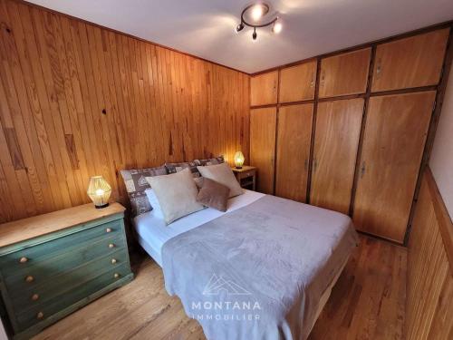 une chambre avec un lit et un mur en bois dans l'établissement Beau 2 pièces au cœur du Grand-Bornand, pour 4 personnes - FR-1-458-219, au Grand-Bornand