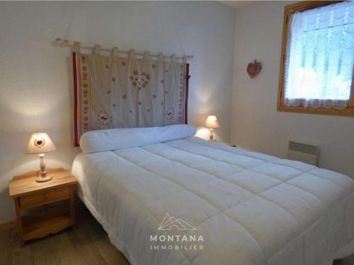 une chambre avec un grand lit blanc et une fenêtre dans l'établissement Confortable 2 pièces + coin nuit, 41m², 4 pers., proche remontées mécaniques - FR-1-458-221, au Grand-Bornand