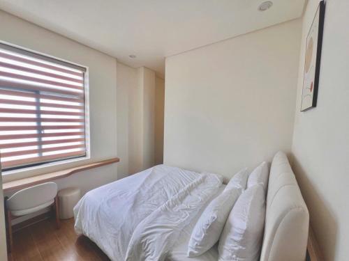 a bedroom with a white bed and a window at At De June 204 in Cu Lao Thu