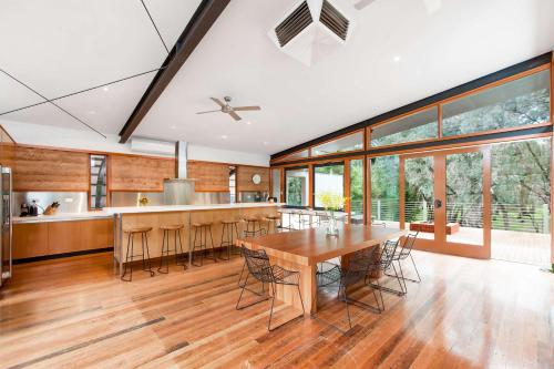 a kitchen and dining room with a wooden table and chairs at Elements - Echuca Holiday Homes in Moama