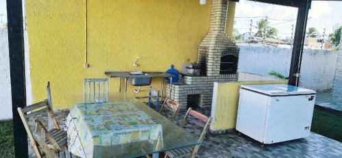 a patio with a brick oven with a table and a table at Casa Sol Nascente JR in Natal