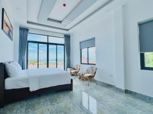 a bedroom with a bed and a large window at An Thới Ocean View - ẩn mình trên cao tầm nhìn ôm trọn biển in Phú Quốc