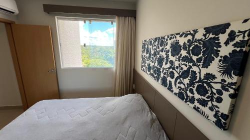 a bedroom with a bed and a window at PARK VEREDAS - Apto 415 - Vista para Piscina in Rio Quente