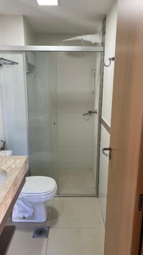 a bathroom with a toilet and a glass shower at PARK VEREDAS - Apto 415 - Vista para Piscina in Rio Quente
