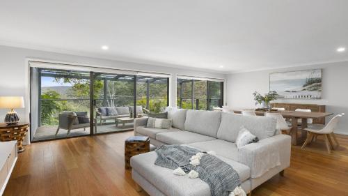 a living room with a couch and a dining room at 'Bay Dreams at Killcare' by HolidayCo in Killcare