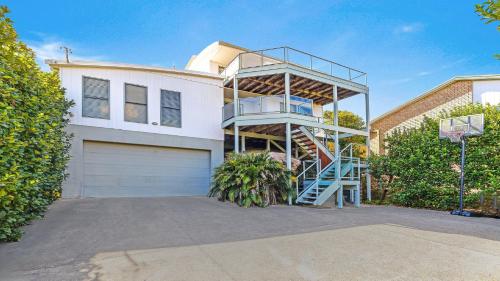 a house with a staircase in front of a garage at 'Headlands at Killcare' by HolidayCo in Killcare
