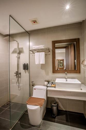 a bathroom with a toilet and a sink and a shower at Astica Hotel Nha trang in Nha Trang