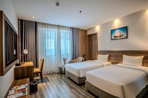 two beds in a hotel room at Astica Hotel Nha trang in Nha Trang