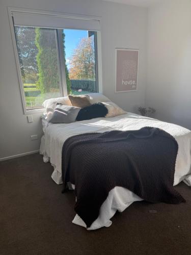 a bedroom with two beds in front of a window at Homewood in Matamata
