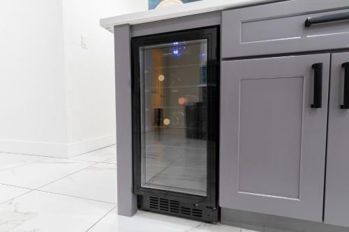 a glass door on a counter in a room at West Palm Beach Elegant 5BR with Hot Tub and Fire Pit Near Beach in West Palm Beach