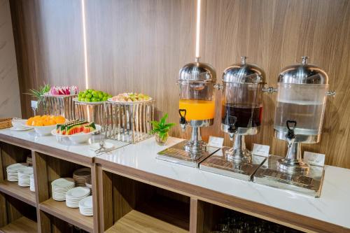 a buffet with drinks and bowls of fruit at Astica Hotel Nha trang in Nha Trang