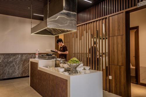 a person standing in a kitchen with a counter at Astica Hotel Nha trang in Nha Trang