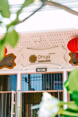 a sign on the wall of a building with windows at O'nya Phuket Hotel in Phuket