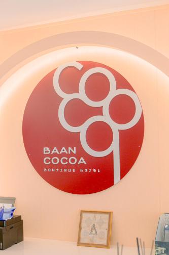 a red and white sign on a wall at Baan Cocoa Boutique Hotel in Natai Beach