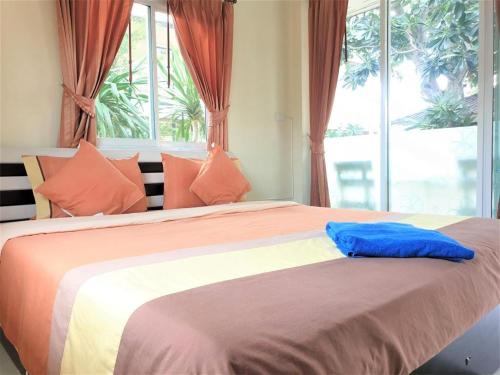 a large bed with a blue pillow on top of it at Sea Beach Koh Larn 1 in Ko Larn