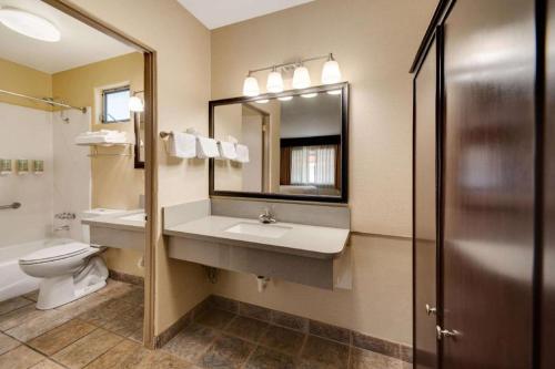 a bathroom with a sink and a toilet and a mirror at Best Western Frontier Motel in Lone Pine