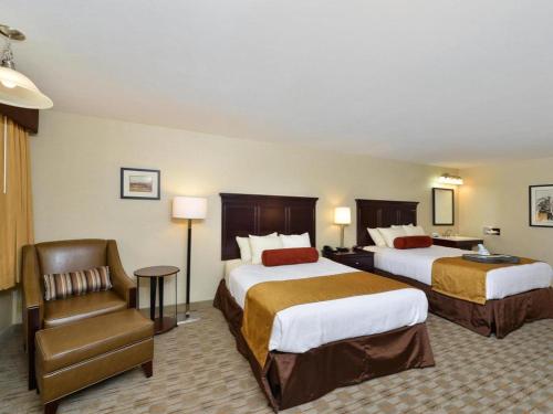 a hotel room with two beds and a chair at Best Western Frontier Motel in Lone Pine