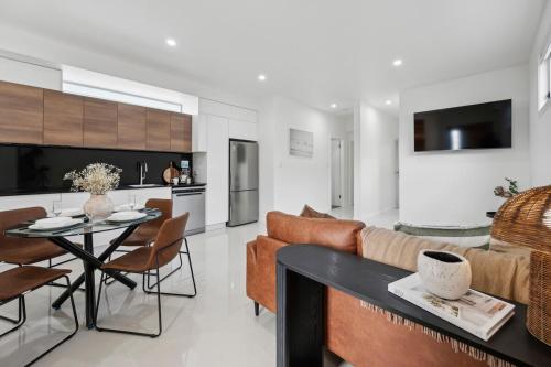 a living room and kitchen with a couch and a table at The Break on Diggers - Popular Location, walk to Beach in Coffs Harbour