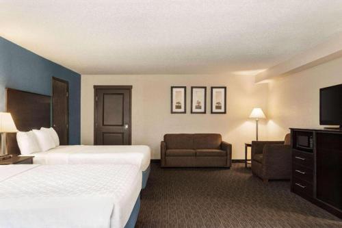 a hotel room with two beds and a television at AmericInn by Wyndham La Crosse Riverfront-Conference Center in La Crosse