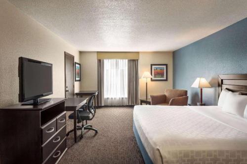 a hotel room with a bed and a flat screen tv at AmericInn by Wyndham La Crosse Riverfront-Conference Center in La Crosse