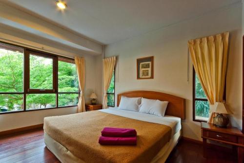 1 dormitorio con 1 cama grande y 2 toallas rojas. en Cha Am Villa Beach, en Ban Bo Khaem