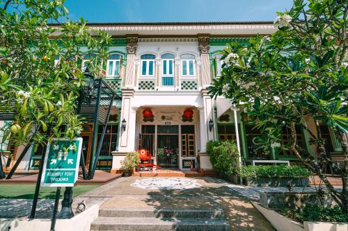 a large white house with trees in front of it at O'nya Phuket Hotel in Phuket