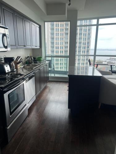 a kitchen with stainless steel appliances and large windows at Downtown Toronto Suite By The Water in Toronto