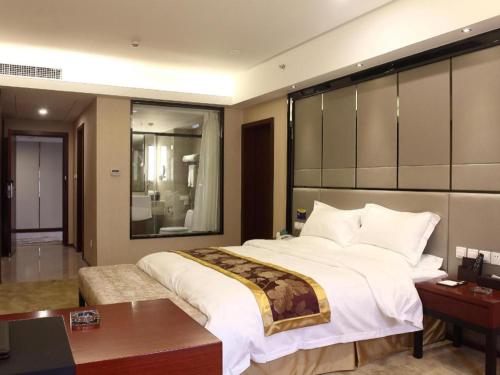 a bedroom with a large bed and a desk at Chengdu Antai Century Hotel in Chengdu