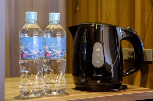 two bottles of water sitting next to a coffee maker at Tosei Hotel Cocone Kamata in Tokyo