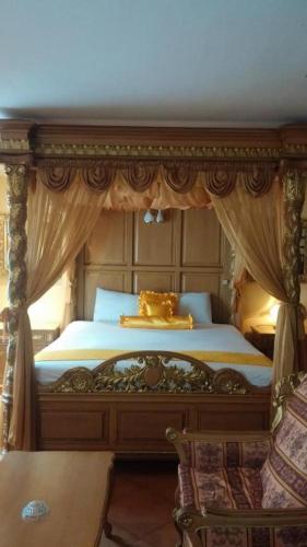 a bedroom with a canopy bed with a chair at Swiss Chalet in Angeles