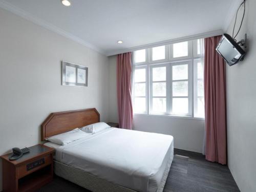 a hotel room with a bed and a window at Penta Hotel in Singapore