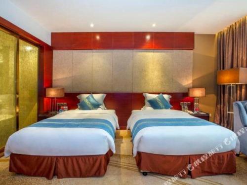 a hotel room with two beds in a room at Quanzhou Jinjiang Hollyston Hotel in Quanzhou