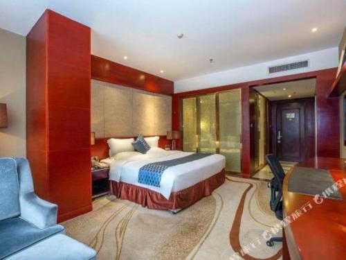 a bedroom with a bed and a desk and a chair at Quanzhou Jinjiang Hollyston Hotel in Quanzhou