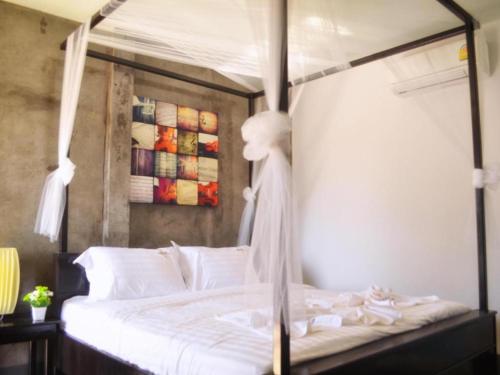 a bed with white sheets and white pillows at The Key Hotel in Ko Lipe