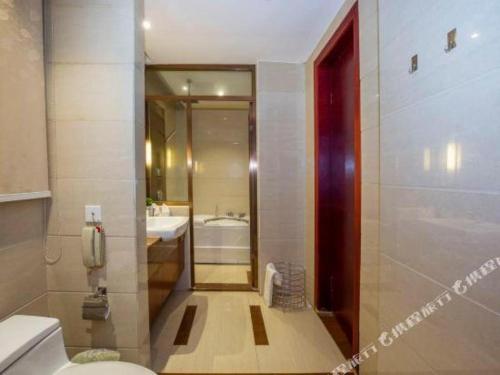 a bathroom with a toilet and a sink at Quanzhou Jinjiang Hollyston Hotel in Quanzhou