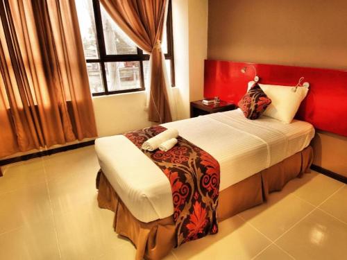 una camera con letto con testiera rossa di Big Daddy Hotel and Convention Center a Butuan