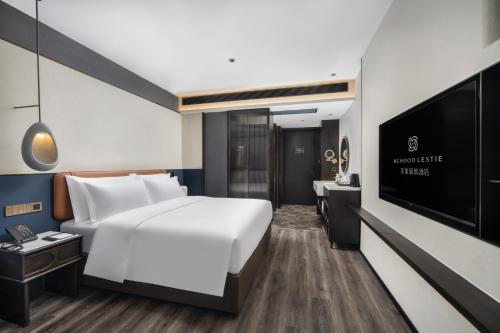 a hotel room with a bed and a flat screen tv at Mehood Lestie, Kashgar Donghu Lake in Kashgar